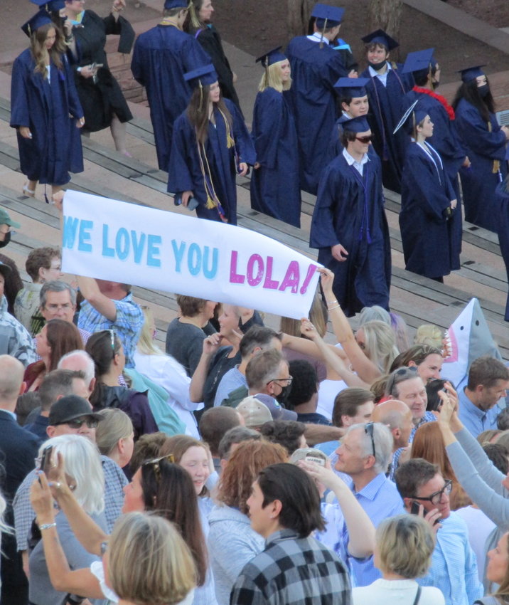 Family members hold a sign congratulating their graduate at the students filed into their seats at Red Rocks Ampitheatre.